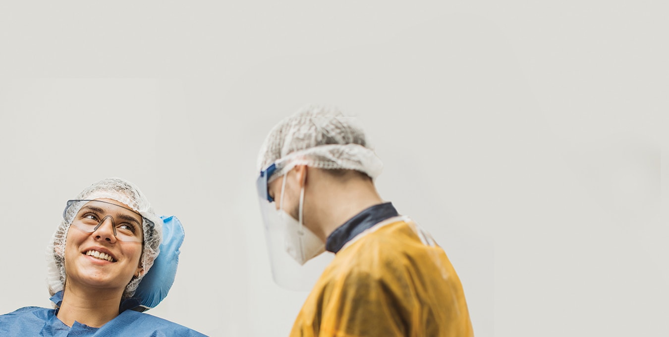 dental hygienist and patient in full PPE gear having a conversation