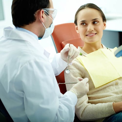 Doctor and patient looking at each other as patient sits in chair 