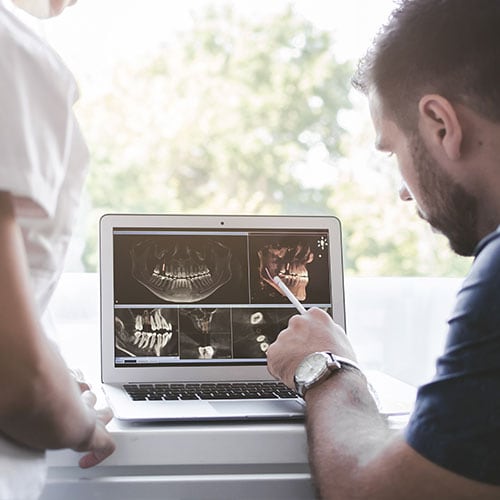 male-dentist-explaining-dental-xray-female