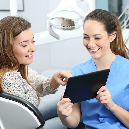 Patient pointing at the screen of the tablet that the nurse is holding 